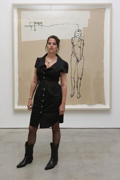 a woman standing in front of a painting