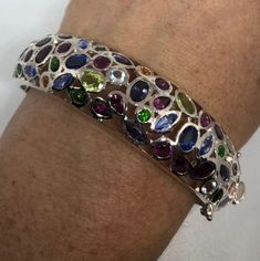 Huge natural Mixed colored gemstone set in a flower design Wrap around bangle fits 5-8 inch wrist. All hand made 925 Sterling Silver The pattern has a space near the clasp that looks like missing stone, but it is not. All jewelry is shipped in a nice gift box. Check out our over a THOUSAND great reviews Engraving is $4 per letter and is not always perfect depending on the piece. It can take a few days if the jeweler is busy. This is payable to Paypal Judithsltd@gmail.com Elegant Multicolor Stone Bangle, Sterling Silver Multi-stone Bracelet, Formal Multi-stone Gemstone Bangle, Fine Jewelry Sterling Silver Gemstone Bangle, Sterling Silver Gemstone Bangle Bracelet, Elegant Multicolor Sterling Silver Bracelet, Sterling Silver Multicolor Gemstone Bracelet, Multicolor Gemstone Sterling Silver Bracelet, Elegant Multicolor Sterling Silver Bracelet With Stones