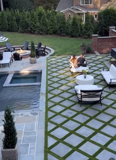 an outdoor living area with chairs and tables next to a swimming pool in the backyard