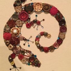 a close up of a clock made out of buttons and other items on a wall