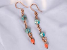 These lightweight art deco dangle earrings feature blue jasper gemstones and up-cycled coral-colored glass beads wrapped in high-quality pure copper. Flaunt this elegant organic look with a breezy deco feel to compliment your style and elevate any outfit. This piece is part of the Sunset Festival collection. Inspired by the vibrant and eclectic festivals in tropical settings, this collection bursts with color and playful designs that capture the lively and colorful essence of lush festivals and Nickel-free Bohemian Earrings For Vacation, Bohemian Nickel Free Earrings For Vacation, Bohemian Nickel-free Earrings For Vacation, Bohemian Earrings With Ear Wire For Vacation, Bohemian Ear Wire Jewelry For The Beach, Bohemian Ear Wire Jewelry For Beach, Bohemian Jewelry With Ear Wire For Beach, Beach Wire Wrapped Drop Earrings, Artsy Wire Wrapped Dangle Jewelry