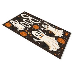 a halloween door mat with ghost, pumpkins and bats on it's side