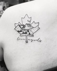 the back of a woman's shoulder with a canadian maple leaf tattoo on it