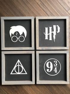 four framed harry potter signs on a wooden table