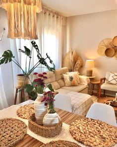 a living room filled with lots of furniture and flowers on top of a wooden table