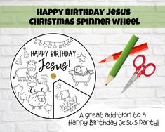 a happy birthday jesus card with scissors and pencils next to the coloring page on a white brick wall