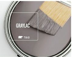 a gray paint can with a yellow brush in it and the words grayac above it