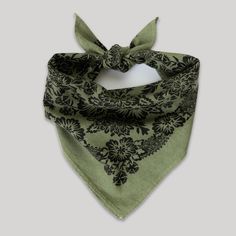 a green bandana with black flowers on it