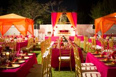 tables set up for an event with orange and pink linens