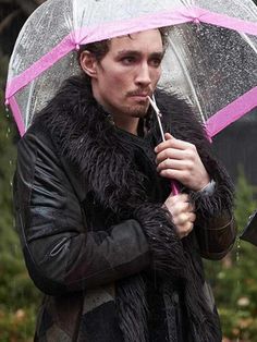 a man holding an umbrella while standing in the rain