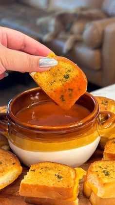 a person dipping some bread into a bowl