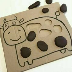 a cardboard box that has some rocks in it and a cow drawn on the side