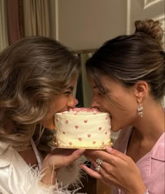 two women sharing a piece of cake with each other