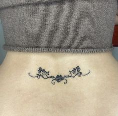 a woman's lower back tattoo with vines and flowers on her left side ribcage