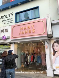 a man and woman standing in front of a clothing store with mannequins on display