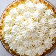 a pie topped with whipped cream on top of a table