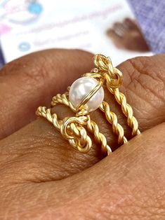 "Beautiful and unique Pearl Gold Wire Wrapped Ring, ideal for an special gift for her, it's very elegant and will make her get many compliments.  This ring is made with a 6mm round pearl and wrapped in non tarnish gold wire. It is made to order in the size of your choice.  I T E M ~D E T A I L S Materials: Gold Plated Twisted Wire, Swarovski 6mm Pearls. Size: See Variations. Thank you for visiting my product. You can see more amazing designs in my shop clicking here: https://www.etsy.com/shop/Na Handmade Gold Pearl Promise Ring, Adjustable Gold Pearl Promise Ring, Elegant Adjustable Hand-wrapped Rings, Elegant Gold Hand Wrapped Rings, Elegant Wire Wrapped Toe Rings, Elegant Wire Wrapped Promise Ring, Elegant Hand Wrapped Rings For Anniversary, Gold Pearl Rings As A Gift, Gold Pearl Toe Ring As Gift