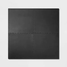 a black square with lines drawn on it in front of a white wall and floor