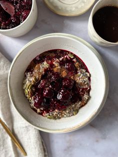 a bowl filled with oatmeal and fruit on top of a white table