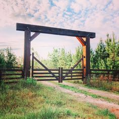 an open gate in the middle of a grassy field