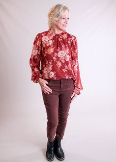 Staccato Ruffle Neck Blouse with Long Sleeves is a beauty with its deep colors of fall! Here’s What We Love About This Item: Beautiful long sleeve top with ruffled neck and sleeves Rust and cream with brushes of purple and rose gold flecks Bodice is fully lined, sleeves are sheer with gathered shoulder seam High-low hem 100% Polyester Imported Our Styling Tips: Dress up this rust colored (Marsala) floral top by pairing with wide leg pants or suede slacks for the Holidays. Go casual with jeans (pictured here) and shoe boots. Beautifully versatile blouse, lined with a detail of rose gold flecks. Brand Information: Here in our store, customers love Staccato for its quality construction at affordable prices. Staccato’s merchandise is always trendy but very wearable and all for prices that usua Fall Top With Blouson Sleeves And Ruffled Collar, Fall Tops With Blouson Sleeves And Ruffled Collar, Floral Print Blouse With Ruffled Collar For Fall, Fall Floral Print Blouse With Ruffled Collar, Workwear Tops With Ruffled Collar For Fall, Fall Workwear Tops With Ruffled Collar, Ruffle Neck Blouse, Blouse With Long Sleeves, Colors Of Fall