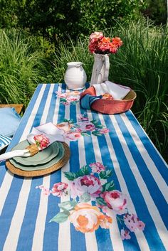 a blue and white striped table cloth with flowers on it