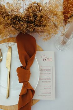 a table setting with place settings and napkins on it, along with a gold fork