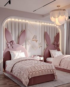 two beds in a room with pink comforters and pillows on the bed, one has an egg shaped headboard