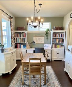 a dining room table and chairs in front of bookshelves