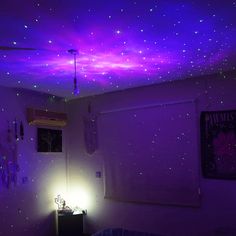 a bedroom with purple lights and stars on the ceiling