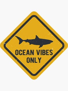 a yellow sign that says ocean vibes only with a black shark on the bottom