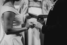 the bride and groom are exchanging their wedding rings at the alter in this black and white photo