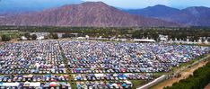 an aerial view of a large parking lot with mountains in the background