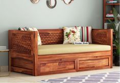 a wooden day bed with drawers underneath it