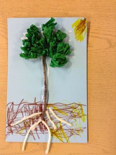 an art project made out of paper and colored crayons with a tree on it