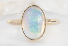 The Hazel Ring with an Australian Opal Oval Cabochon Opal Ring With Polished Finish, Celestial Oval Cabochon Rings, Modern Oval Cabochon Moonstone Ring, Modern Oval Yellow Gold Opal Ring, Modern Yellow Gold Oval Opal Ring, Modern Oval Opal Ring In Yellow Gold, Modern Gold Oval Opal Ring, Elegant Oval Opal Ring With Polished Finish, Formal Oval Cabochon Moonstone Ring