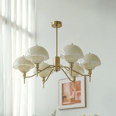 a chandelier hanging from the ceiling in a room with white walls and windows