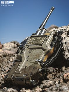 a close up of a remote control device on some rocks and dirt with the sky in the background