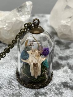 This handcrafted skull terrarium is perfect for anyone who wants to wear a touch of macabre. Whether you love nature or just like bones, this necklace is a cute wearable oddity.  The glass dome measures approx. 30x20mm. The glass is adhered to the base. The contents are secured inside and should not move about. The bronze chain necklace is 20".  The skull is real, ethically sourced from natures blind box. It was dissected, cleaned, soaked for sterilization & dried. This art piece features dried flowers & preserved moss. No two are the same, so this is truly one of a kind.  This piece comes in a natural unbleached muslin drawstring bag. Ready to be gifted or just cherished for its kooky creepiness.  Tips for care: * Though you can clean the glass dome with windex, I find the best way to giv Bohemian Skull Necklace For Gifts, Bohemian Skull Shaped Necklace For Gift, Bohemian Skull Necklace For Gift, Unique Skull Jewelry For Gift, Skull Terrarium, Bronze Chain Necklace, Real Skull, Preserved Moss, Blind Box