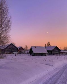 the sun is setting over an old farm in winter