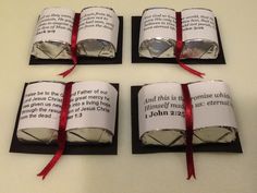 four books wrapped in paper and tied with red ribbon sitting on top of a table