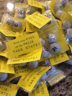 there are many bags of fake eyes on the table with yellow tags attached to them