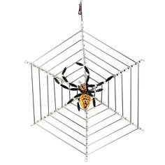 a toy is hanging in the shape of a spider web frame with an orange and black spider inside it