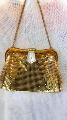 A beautiful example of the classic evening bag from Whiting and Davis, circa 1940. Vibrant gold mesh with lovely pearl glass snap lock closure with cut away and rhinestone detail. The purse is in very nice vintage condition, with very little signs of wear and tear. The interior lining shows some wear with minor stitching starting to unravel on one side. Not a big deal and easily is fixable. It is highly functional and usable as it is. Don't hesitate is ask any other questions or concerns. thank you for your interest. Chain link strap - 10" total length (5" high) Top is 4" side to side Bottom is 6" side to side Top of bag to base is 4" Vintage Evening Bag With Gold-tone Hardware, Victorian Rectangular Evening Bag, Vintage Formal Bags With Gold Clasp, Victorian Rectangular Party Bag, Antique Gold Rectangular Bag, Vintage Rectangular Bag For Events, Antique Style Evening Clutch Bag, Antique Gold Rectangular Evening Bag, Vintage Evening Bag With Gold-tone Hardware For Party