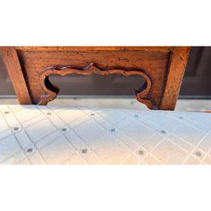 a close up of a bed with a wooden headboard and foot board on it