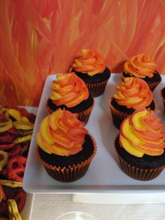 cupcakes with orange frosting on a white plate