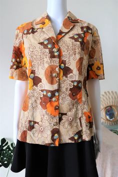 Stunning True Vintage blouse from the 1970s. Comfortable fabric, probably cotton or cotton mix. Amazing floral print in a beautiful color mix with ton-sur-ton embroidered structures in the fabric. Beautiful large golden buttons. BRAND: No brand label, probably custom made ERA: 1970s COLOR: Sand, brown, orange, yellow, blue FABRIC: No fabric tag, probably cotton or a cotton mix SIZE: No size tag, fits best size M - please check measurements below MEASUREMENTS: Pit to pit 48cm, total length 63cm C Vintage Collared Top With Floral Print, Retro Collared Blouse With Floral Print, Retro Button-up Blouse With Vintage Print, Brown Vintage Blouse For Spring, Retro Brown Summer Blouse, Summer Retro Brown Blouse, Vintage Cotton Blouse With Vintage Print, Vintage Patterned Cotton Blouse, Vintage Cotton Patterned Blouse