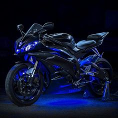 a black and blue motorcycle parked in the dark