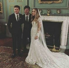 a bride and groom posing for a photo in front of a fireplace