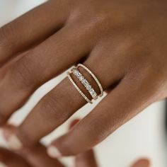 a woman's hand with three rings on it